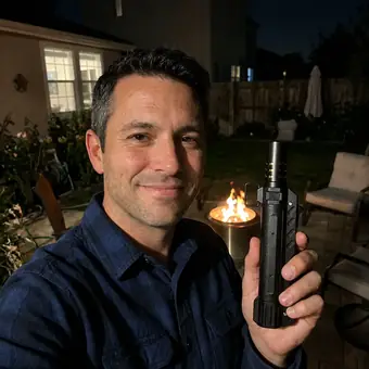 Smiling man on a patio at night holding his TacFlame