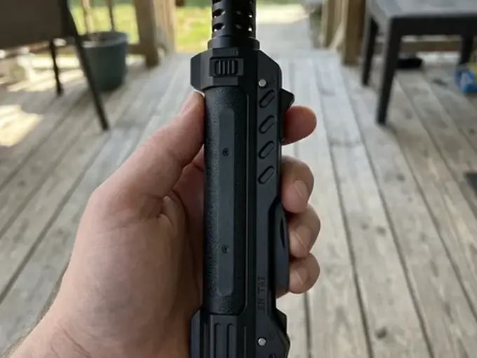 Hand holding the TacFlame torch over a wooden deck