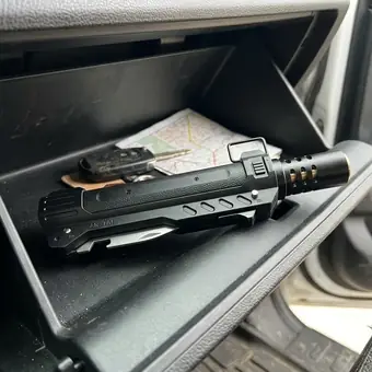 TacFlame stored in an open car glove box next to a folded map